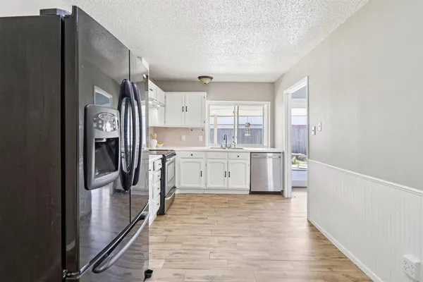 a kitchen with stainless steel appliances a refrigerator sink and cabinets