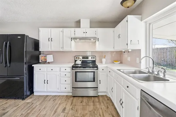 a kitchen with cabinets appliances a sink and a counter top