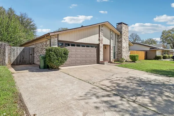 a front view of house with yard and trees around