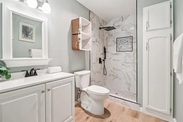 a bathroom with a granite countertop sink toilet and shower