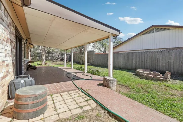 a backyard of a house with fountain table and chairs