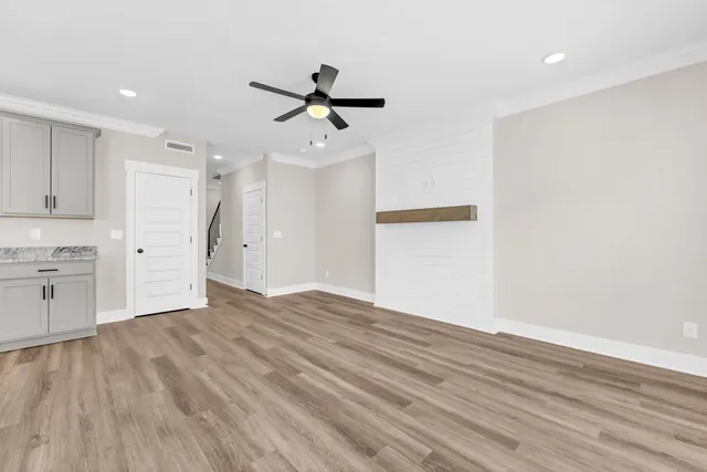 a view of empty room with wooden floor and window