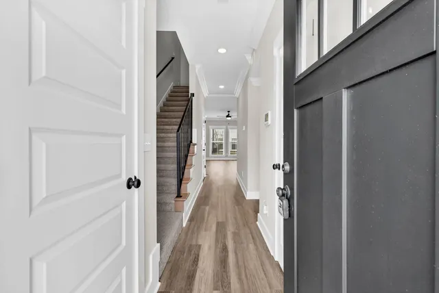 a view of a hallway with wooden floor and staircase