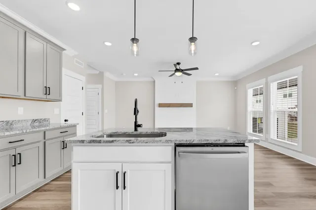 a kitchen with granite countertop cabinets a sink appliances and a counter top space