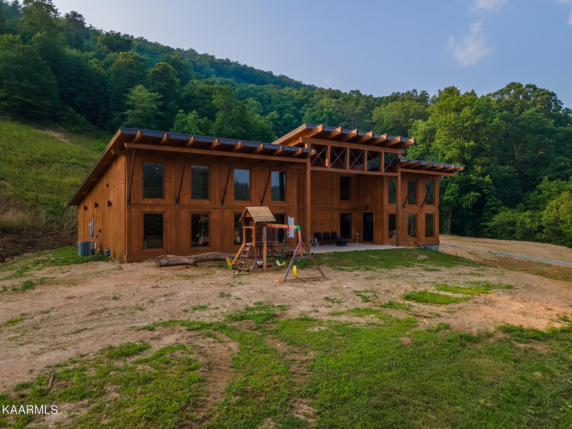 1391 Dutch Valley Road Clinton, TN 37716 - Photo 3 of 44 a view of a wooden house with a yard and large tree