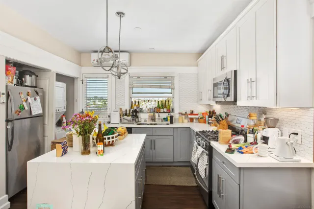 a kitchen that has a lot of cabinets a sink and dishwasher in it