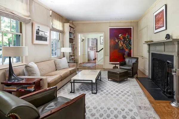 a living room with furniture a fireplace and paintings on the wall