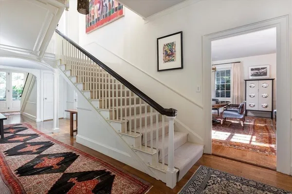 a view of staircase with lots of frames on wall and a rug