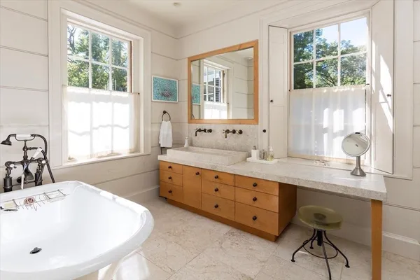 a spacious bathroom with double vanity windows a sink and a mirror
