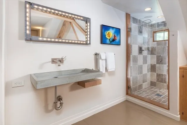 a bathroom with a sink a mirror and glass door