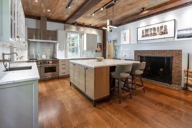 a kitchen with kitchen island a stove a sink a refrigerator and wooden floor