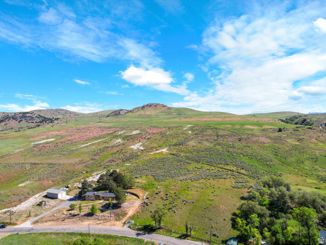 15610 North Beaver Dam Road, Unit 2 Collinston, UT 84306 - Photo 6 of 10 Expansive lot featuring a single-story residence with a detached garage, surrounded by rolling hills and mature trees