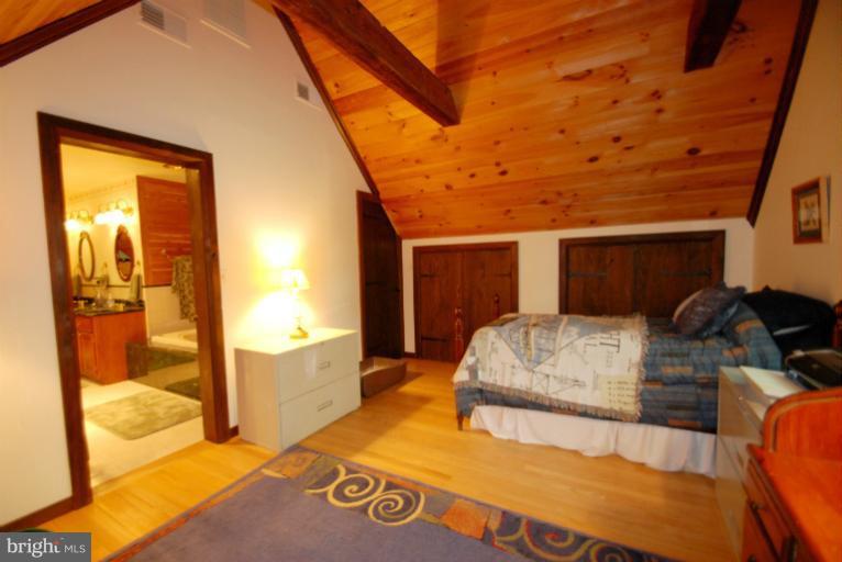 14123 Sunnybrook Road Phoenix, MD 21131 - Photo 23 of 30 a bedroom with a bed and wooden floor
