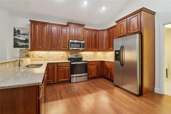 a kitchen with granite countertop stainless steel appliances and wooden cabinets