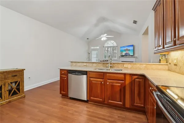 a kitchen with stainless steel appliances granite countertop a refrigerator a stove and a wooden cabinets