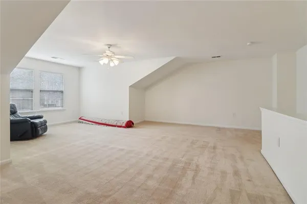a view of a room with a ceiling fan and window