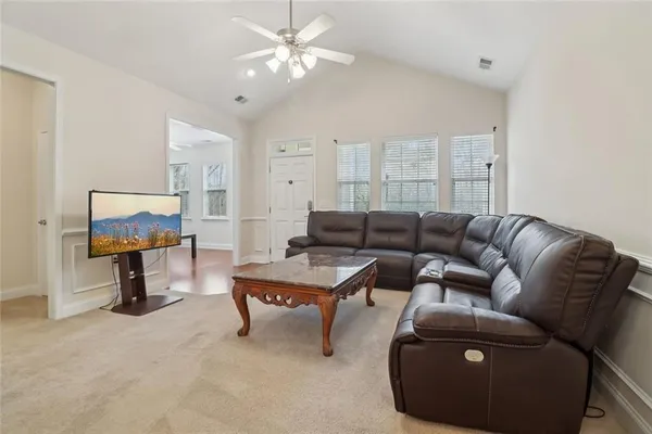 a living room with furniture and a wooden floor