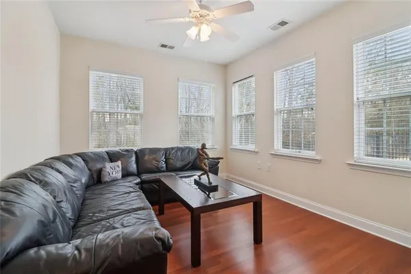 a living room with furniture a dining table and chairs with wooden floor
