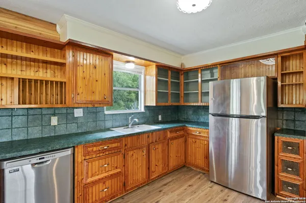 a kitchen with stainless steel appliances granite countertop a refrigerator a sink and dishwasher