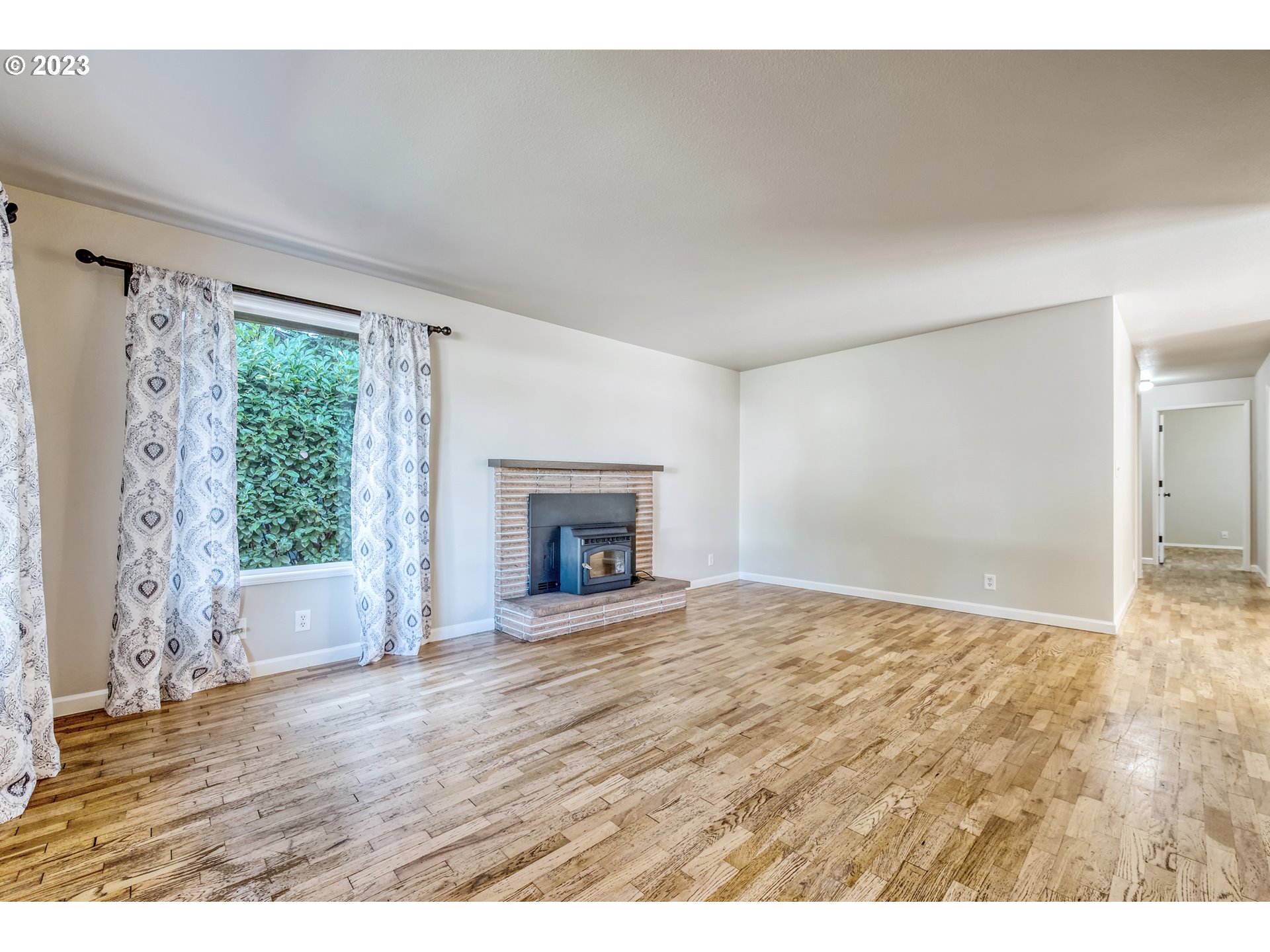4439 Camellia Street Springfield, OR 97478 - Photo 11 of 31 a view of empty room with wooden floor and fireplace