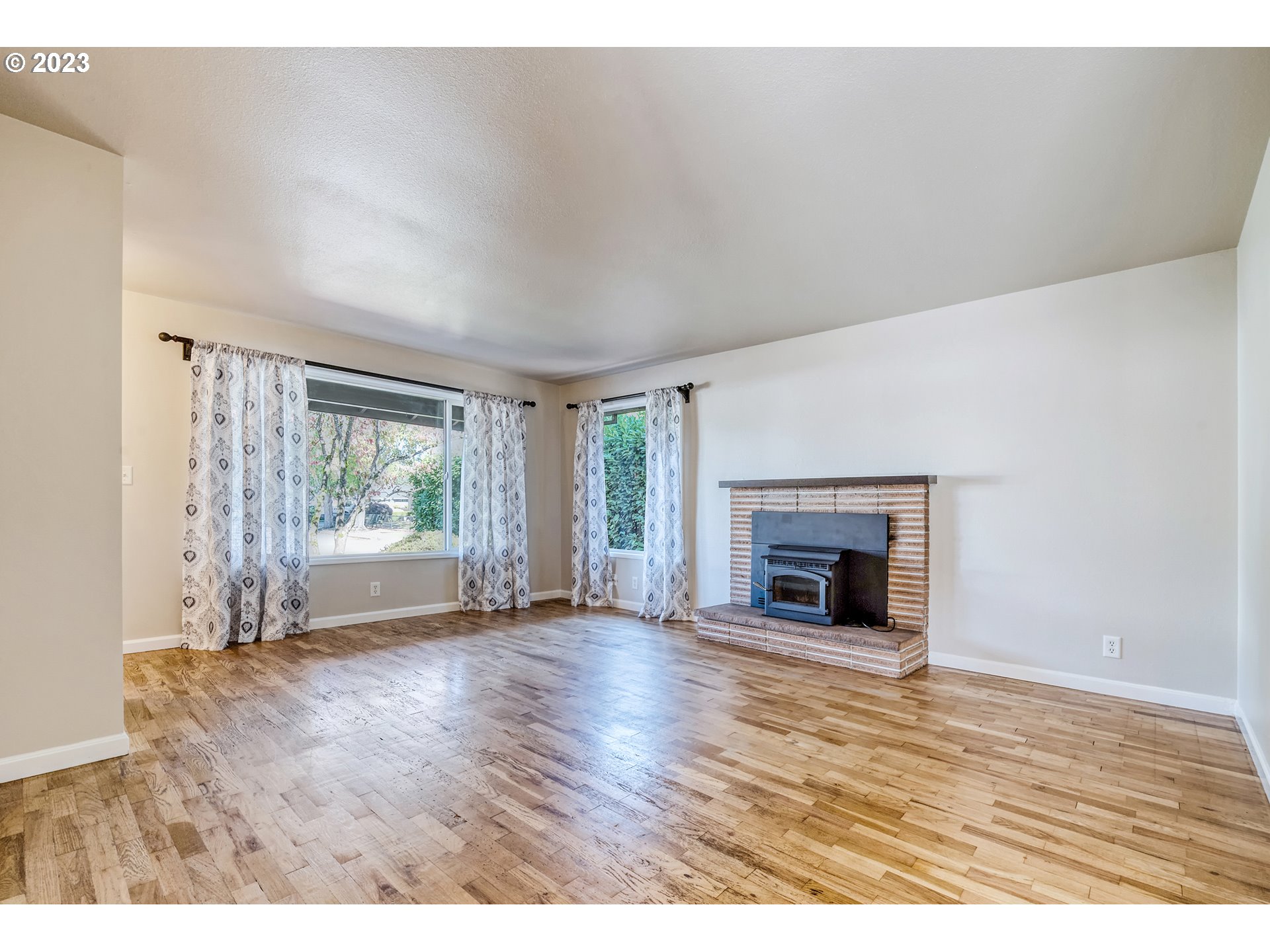 4439 Camellia Street Springfield, OR 97478 - Photo 9 of 31 a view of a livingroom with wooden floor a fireplace and window