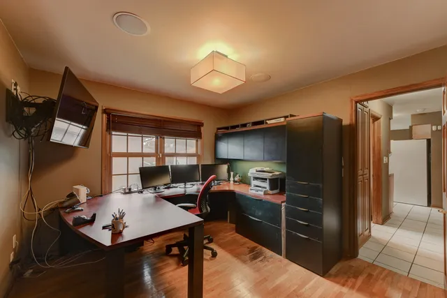 a living room with furniture a flat screen tv and a refrigerator