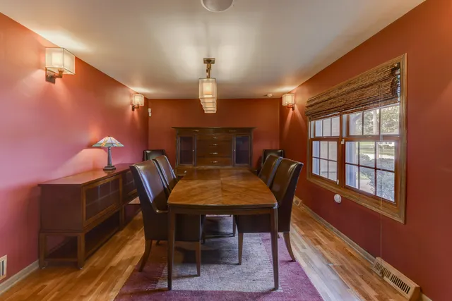 a dining room with furniture a chandelier and wooden floor