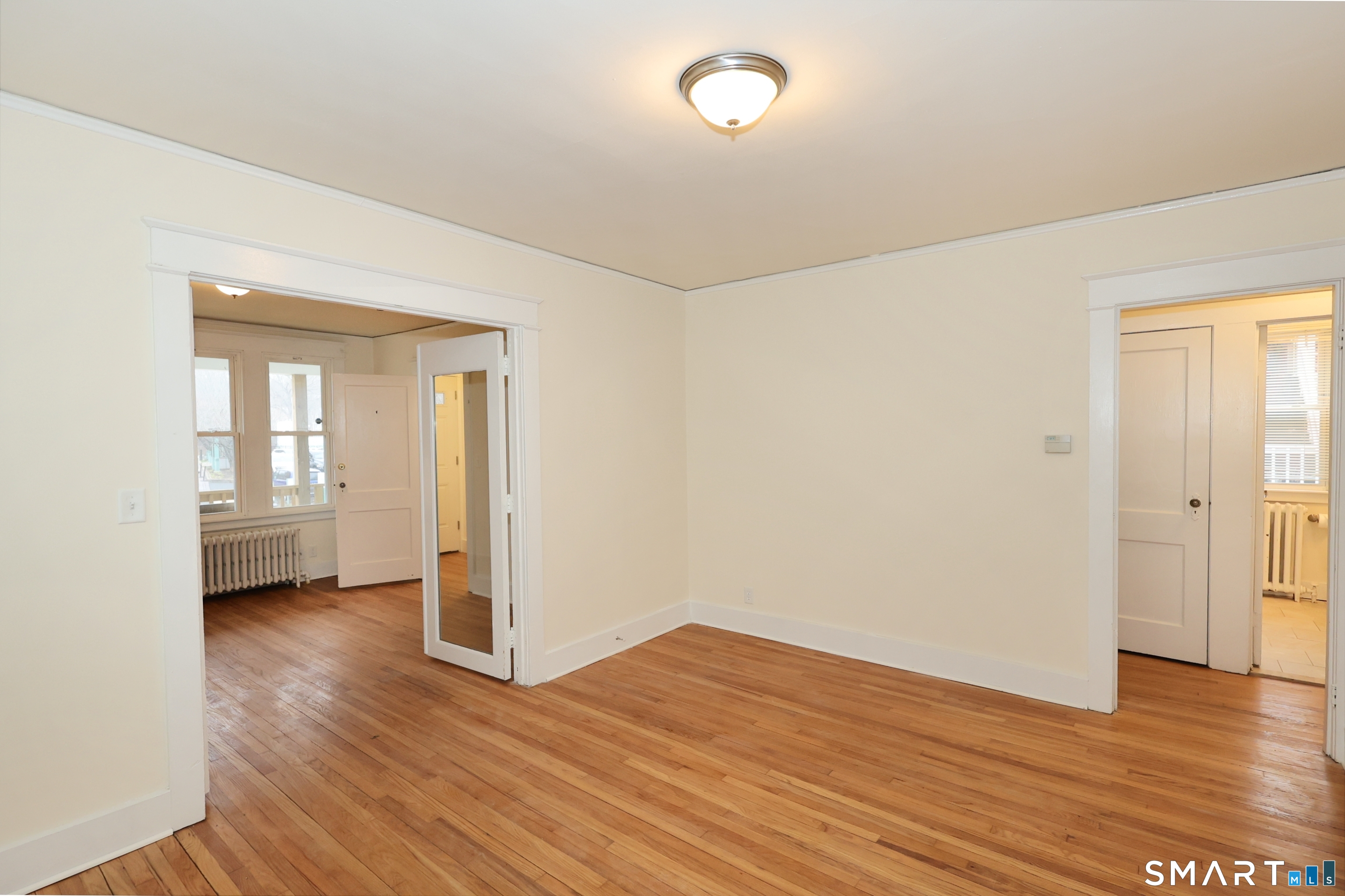 146 Division Street, Unit 1 Ansonia, CT 06401 - Photo 13 of 27 an empty room with wooden floor and windows