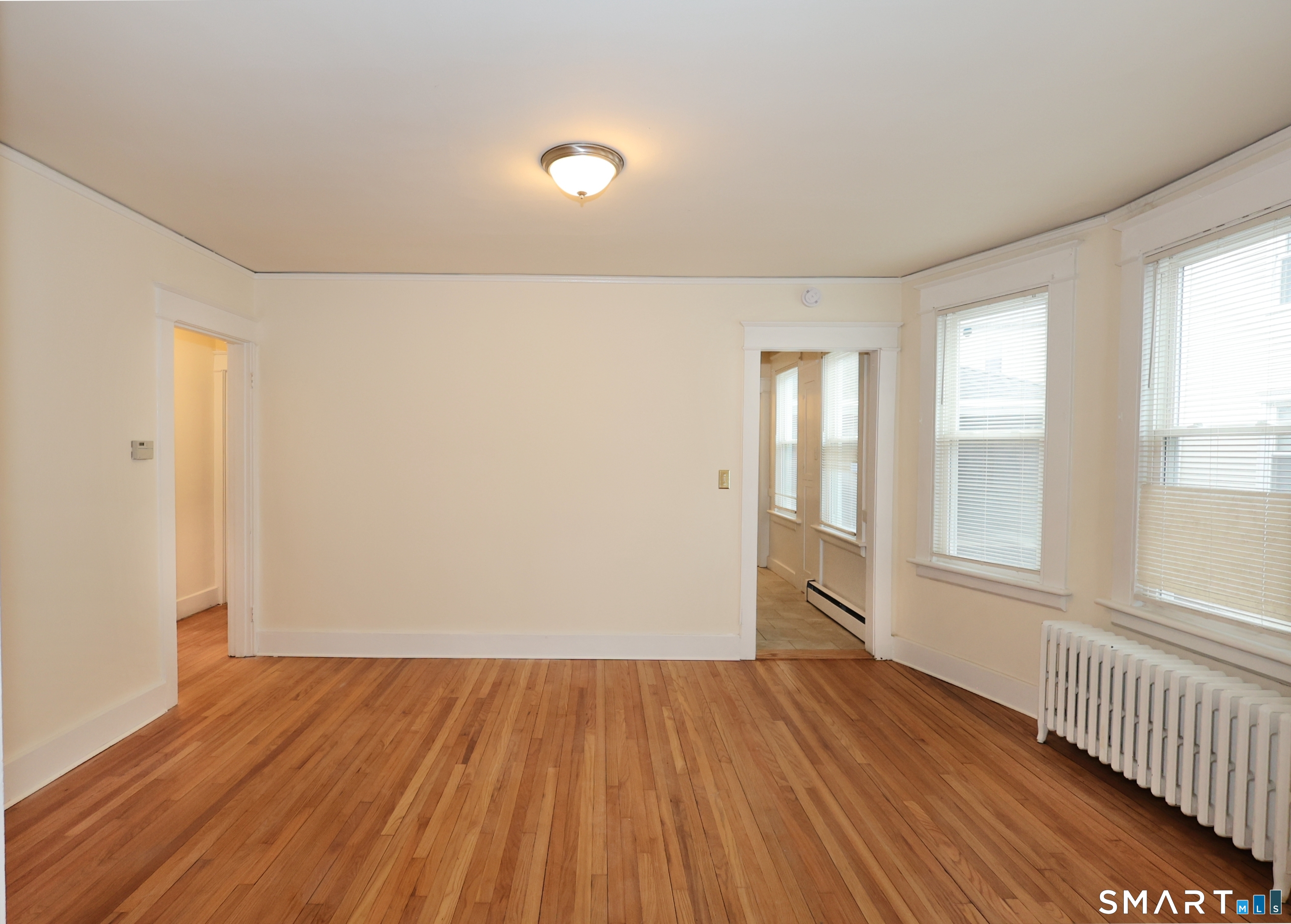 146 Division Street, Unit 1 Ansonia, CT 06401 - Photo 15 of 27 an empty room with wooden floor and windows