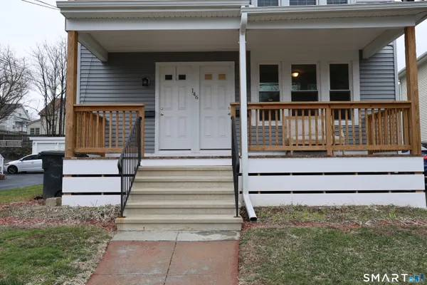 a view of wooden house with a porch