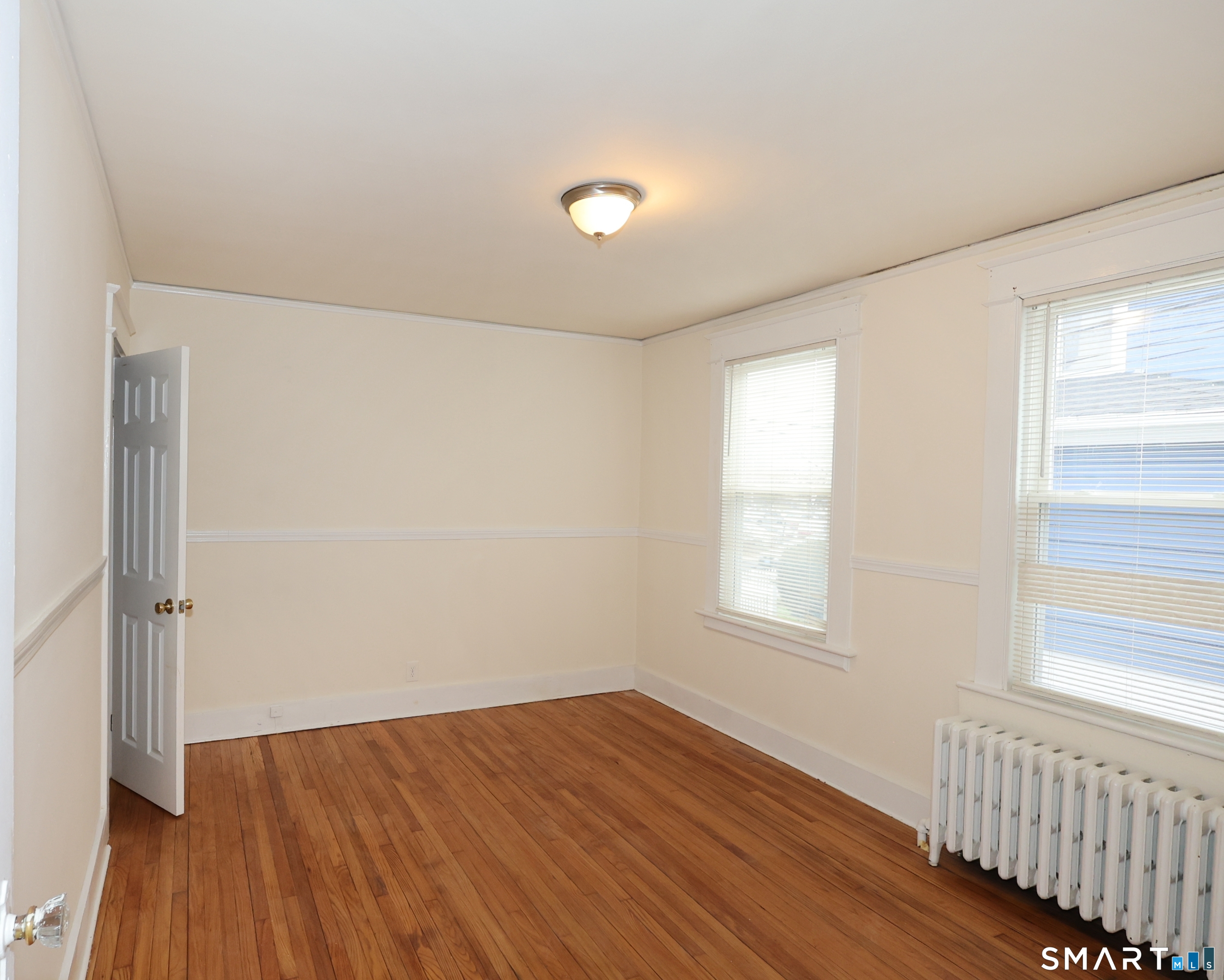 146 Division Street, Unit 1 Ansonia, CT 06401 - Photo 21 of 27 an empty room with wooden floor and windows