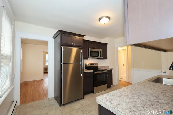 a kitchen with stainless steel appliances granite countertop a refrigerator a stove and a sink