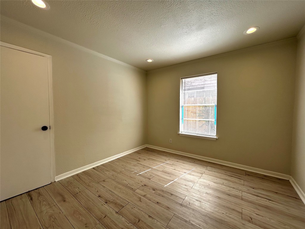1005 West Martin Luther King Jr Boulevard, Unit B Austin, TX 78701 - Photo 16 of 29 a view of an empty room with wooden floor and a window