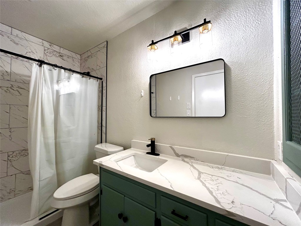 1005 West Martin Luther King Jr Boulevard, Unit B Austin, TX 78701 - Photo 21 of 29 a bathroom with a sink toilet and mirror