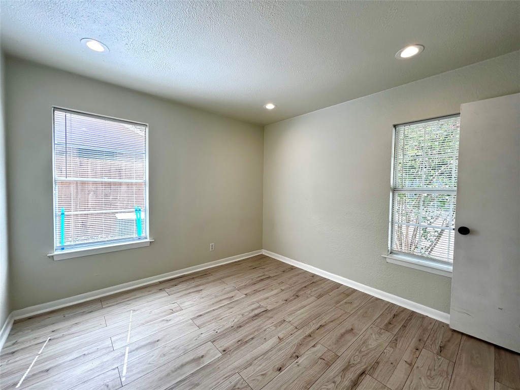 1005 West Martin Luther King Jr Boulevard, Unit B Austin, TX 78701 - Photo 22 of 29 an empty room with wooden floor and windows