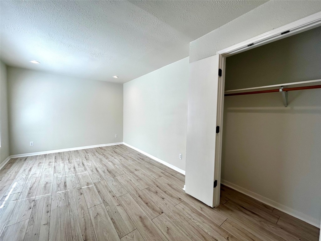 1005 West Martin Luther King Jr Boulevard, Unit B Austin, TX 78701 - Photo 25 of 29 an empty room with wooden floor and windows