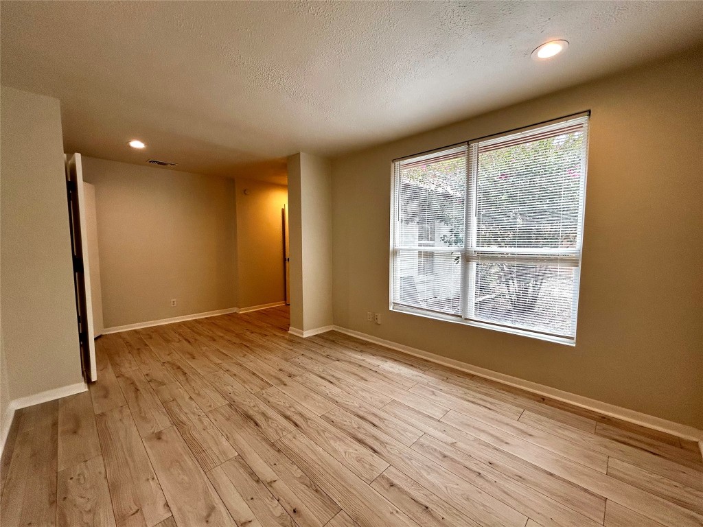 1005 West Martin Luther King Jr Boulevard, Unit B Austin, TX 78701 - Photo 27 of 29 an empty room with wooden floor and windows