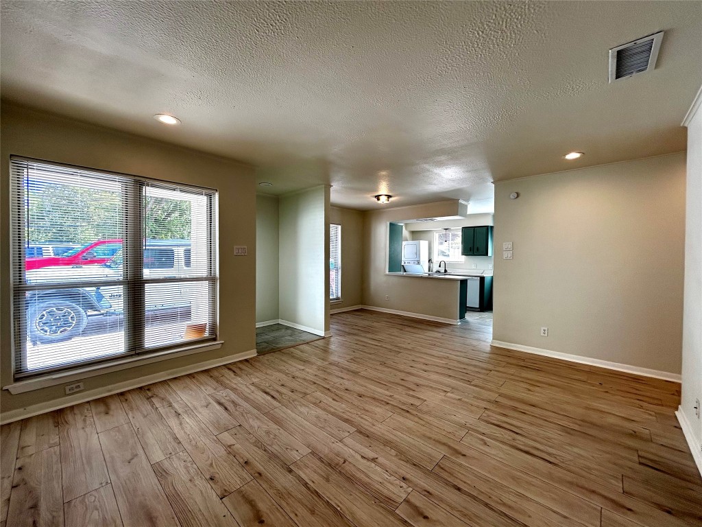1005 West Martin Luther King Jr Boulevard, Unit B Austin, TX 78701 - Photo 5 of 29 a view of an empty room with a window and wooden floor