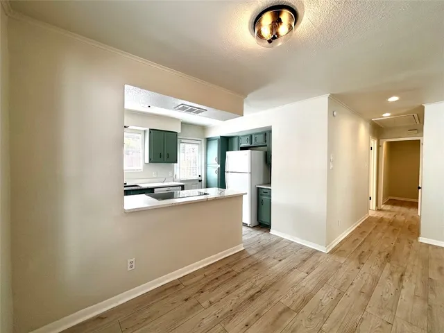 a view of kitchen with stainless steel appliances granite countertop cabinets and wooden floor