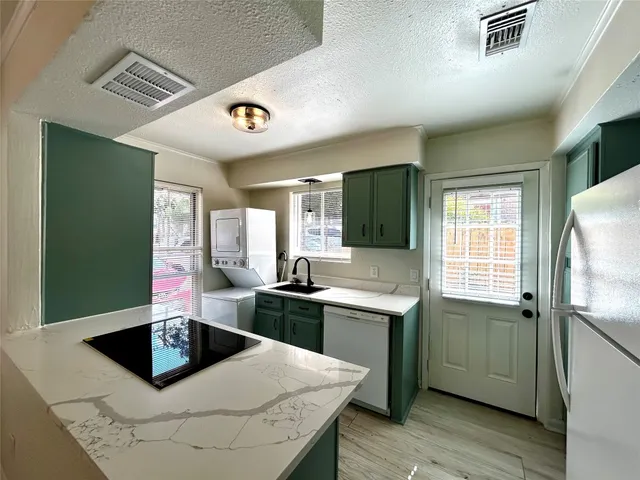 a kitchen with stainless steel appliances kitchen island granite countertop a sink and dishwasher a stove with wooden floor