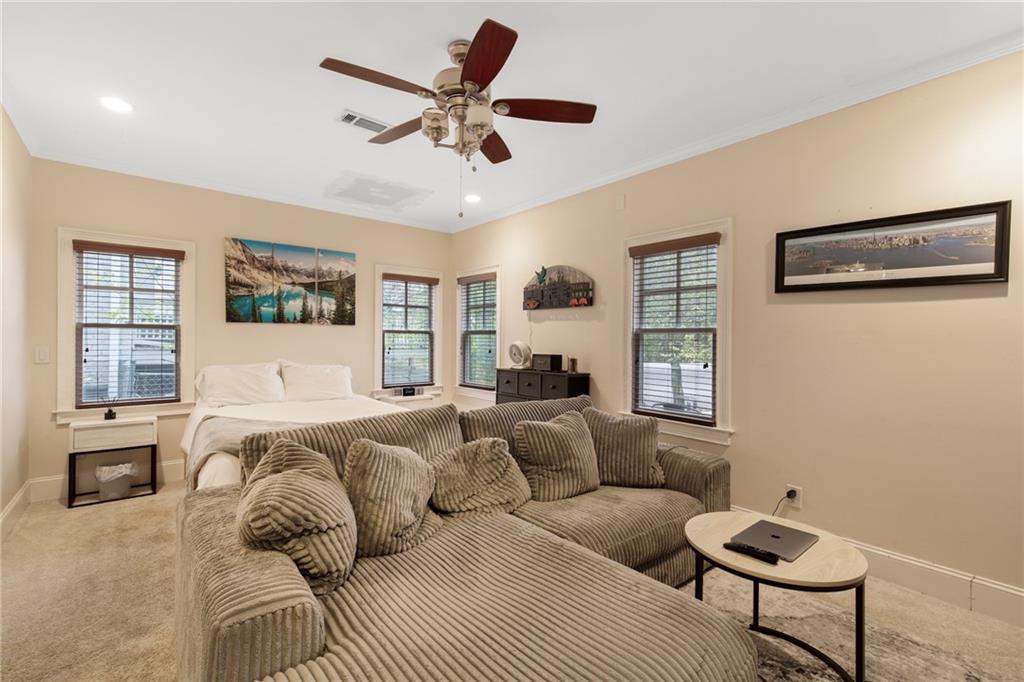 451 Hascall Road Northwest Atlanta, GA 30309 - Photo 16 of 26 a spacious bedroom with a bed a couch and a window