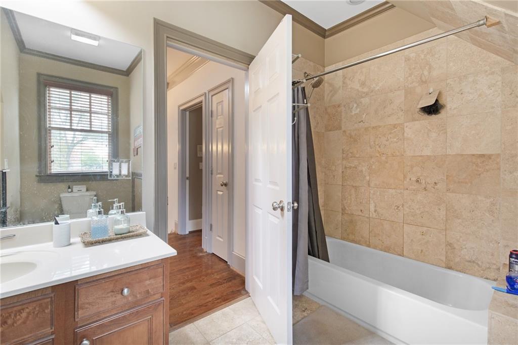 451 Hascall Road Northwest Atlanta, GA 30309 - Photo 23 of 26 a bathroom with a granite countertop sink a mirror and a bathtub