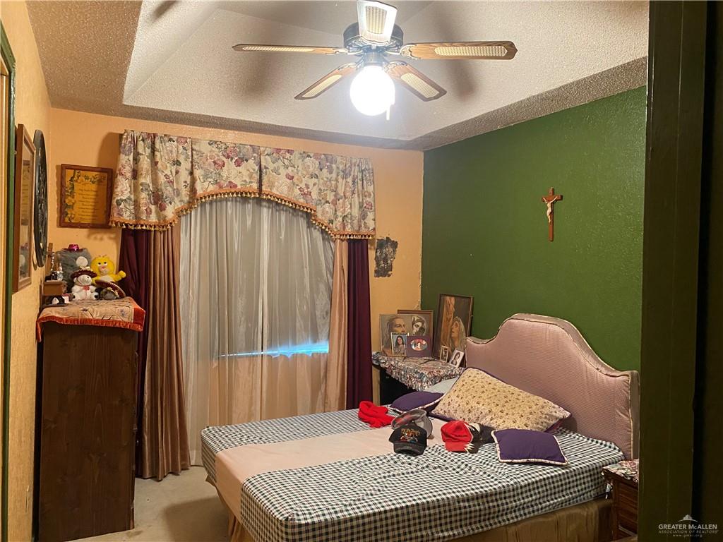 3912-3914 Los Ebanos Road Mission, TX 78573 - Photo 13 of 18 a bedroom with a bed and a chandelier