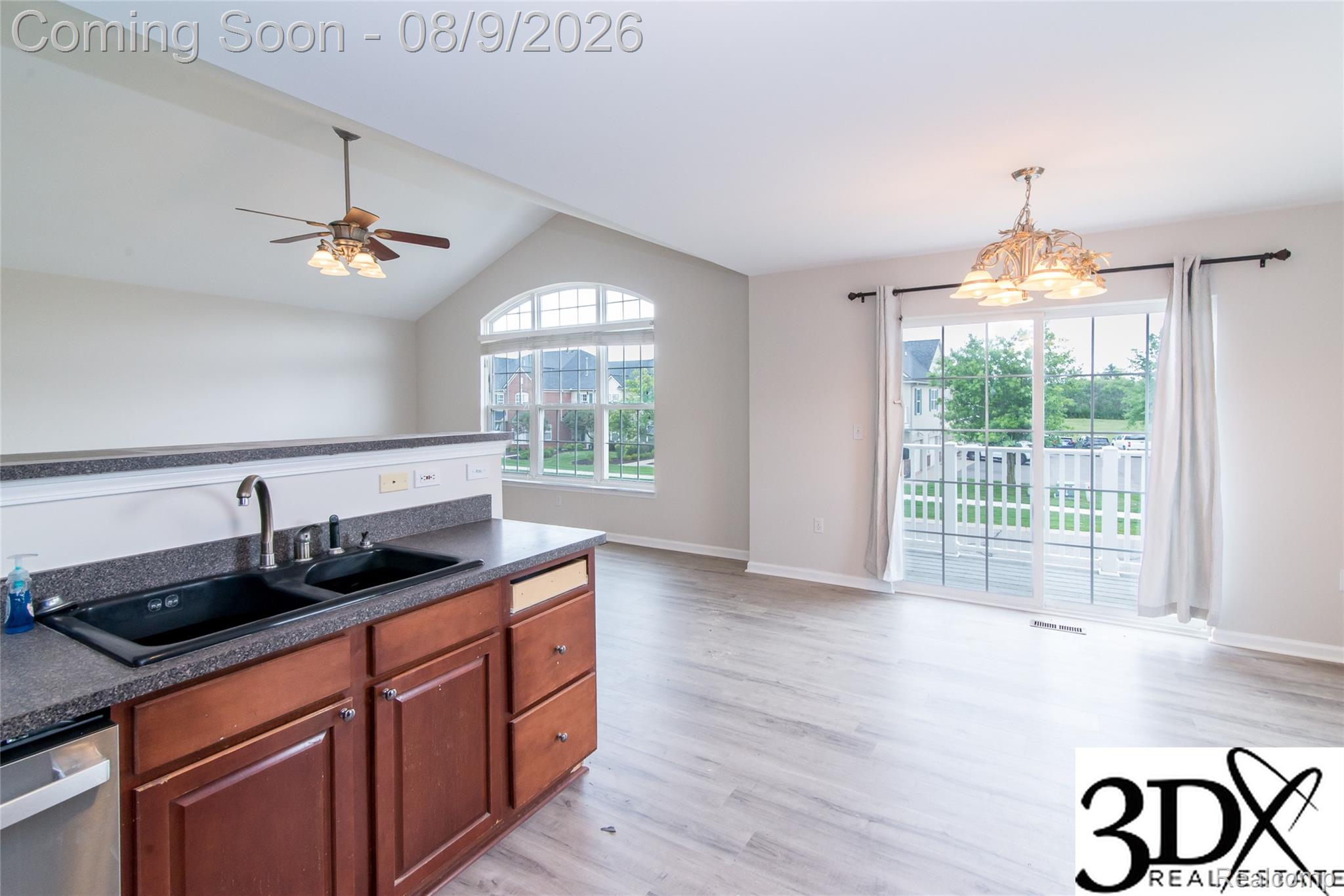 4256 Hampton Ridge Boulevard Howell, MI 48843 - Photo 17 of 26 Open-concept living area featuring vaulted ceilings, wood-finish flooring, and a decorative ceiling fan
