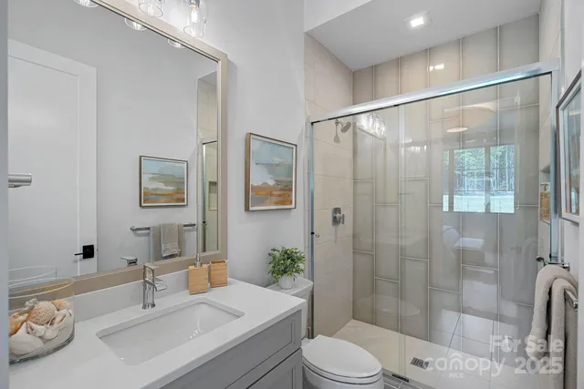 a bathroom with double vanity sinks a large mirror and a shower