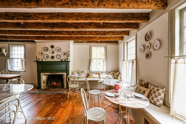 a dining room with furniture a fireplace and wooden floor