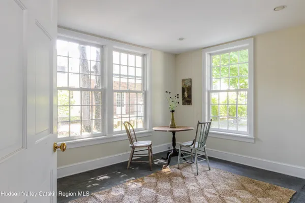 a view of a livingroom with wooden floor and a bathroom