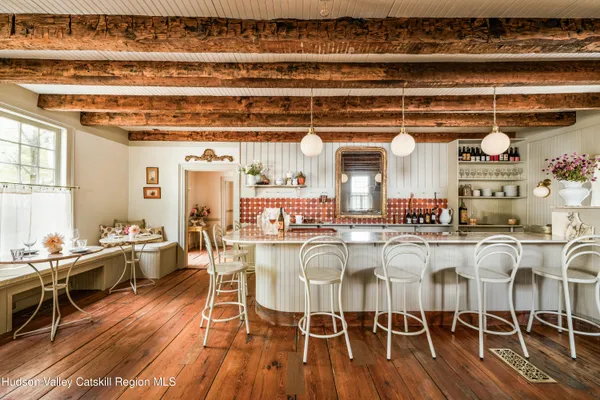 a dining hall with stainless steel appliances granite countertop a stove and cabinets