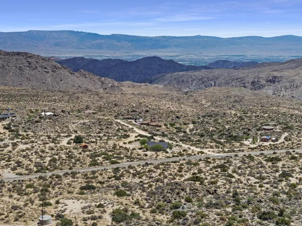a view of a dry yard with mountains in the background