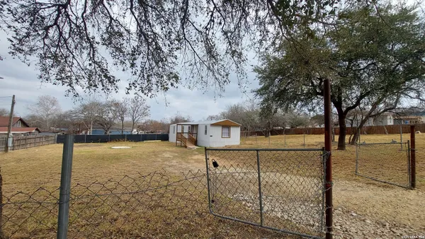 a view of a yard with wooden fence